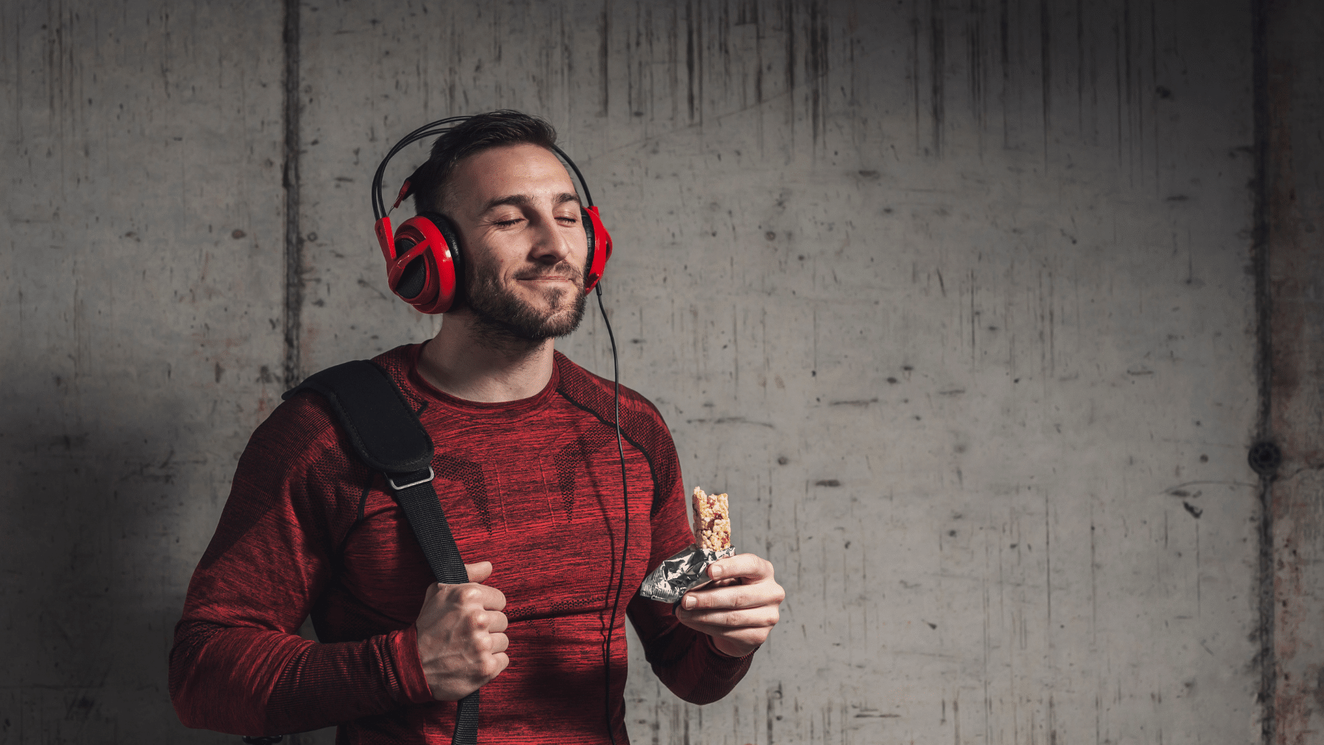 Sportif écoutant de la musique, savourant une barre Protéalpes, nutrition sans édulcorants ni additifs.