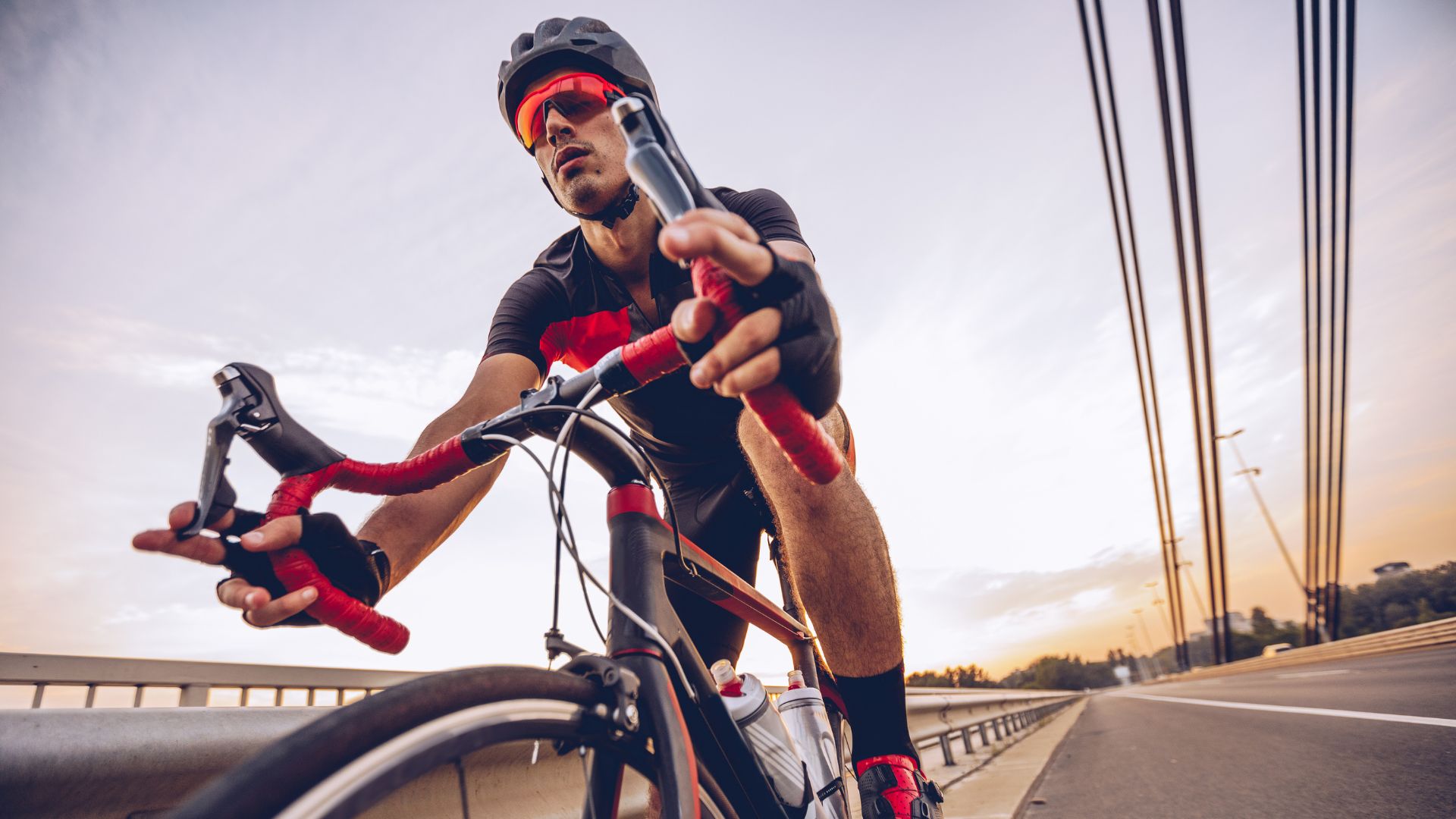 Cyclist on a bridge, illustrating performance with Protéalpes: natural sports nutrition without sweeteners or additives.