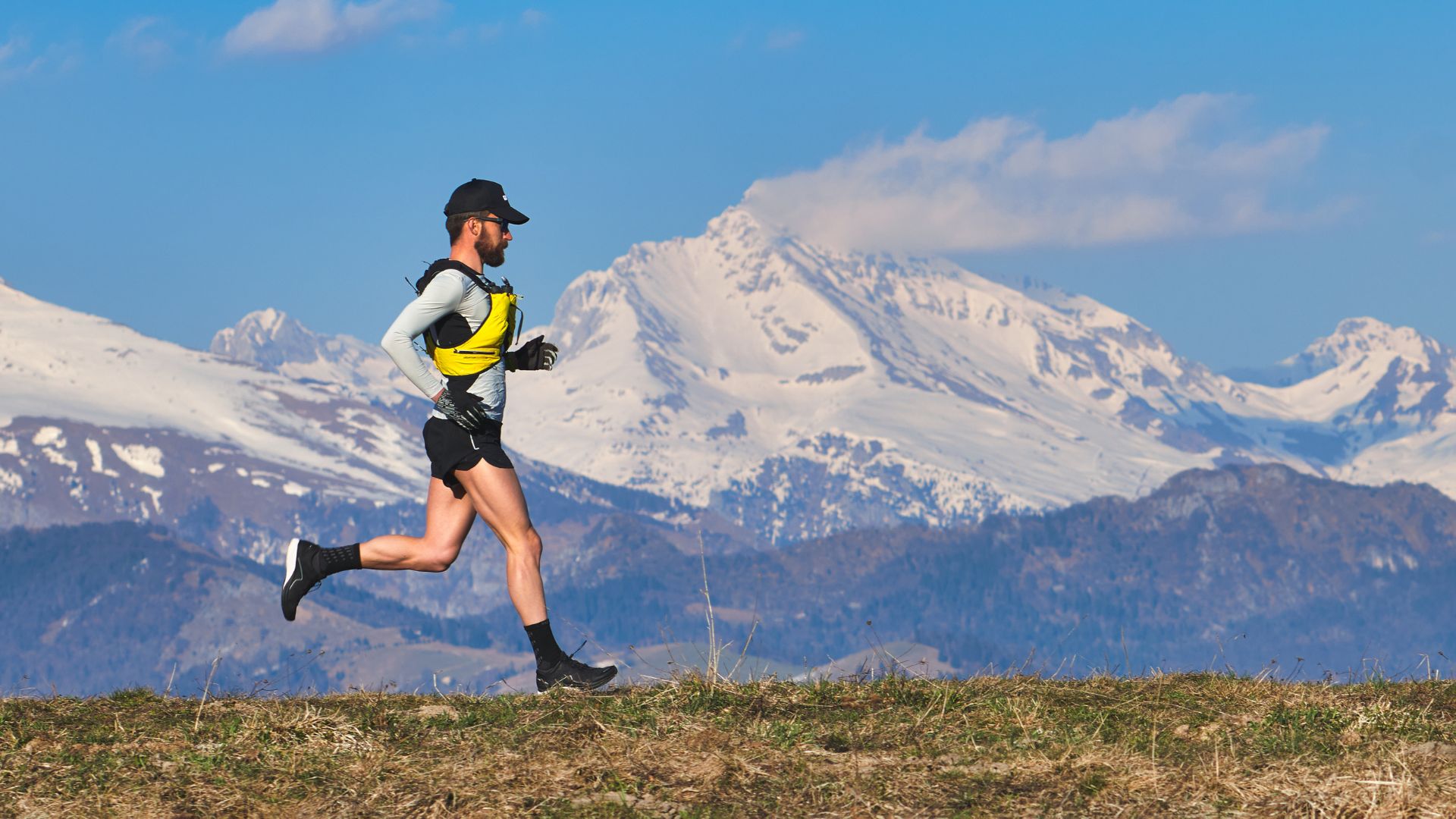 Coureur en montagne avec vue panoramique sur les Alpes, symbolisant l'énergie naturelle et pure des produits Protéalpes.