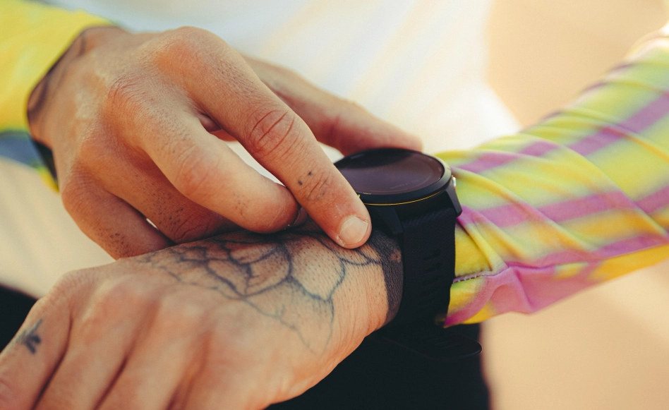 Un sportif avec une montre connectée vérifie ses performances, en lien avec le concept de nutrition pure du site Protéalpes.