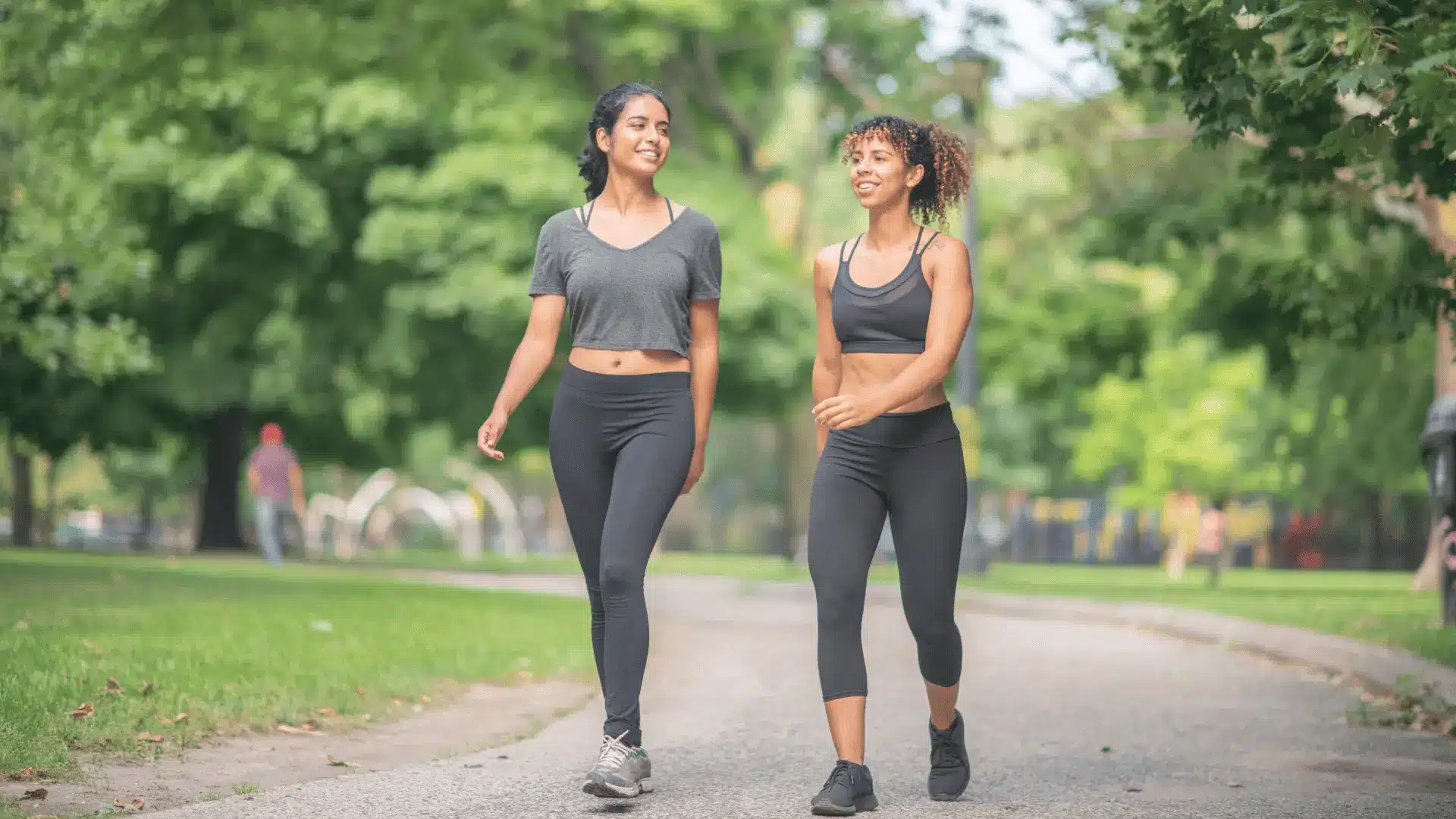 Deux femmes souriantes marchant dans un parc, symbolisant le bien-être et une vie active, en lien avec la nutrition sportive Protéalpes.