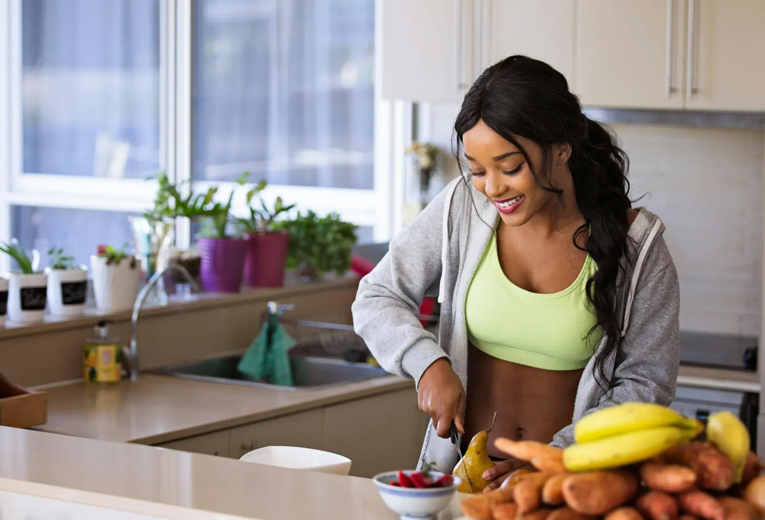 Femme en cuisine préparant des fruits frais, soulignant le mode de vie sain et la nutrition naturelle de Protéalpes.