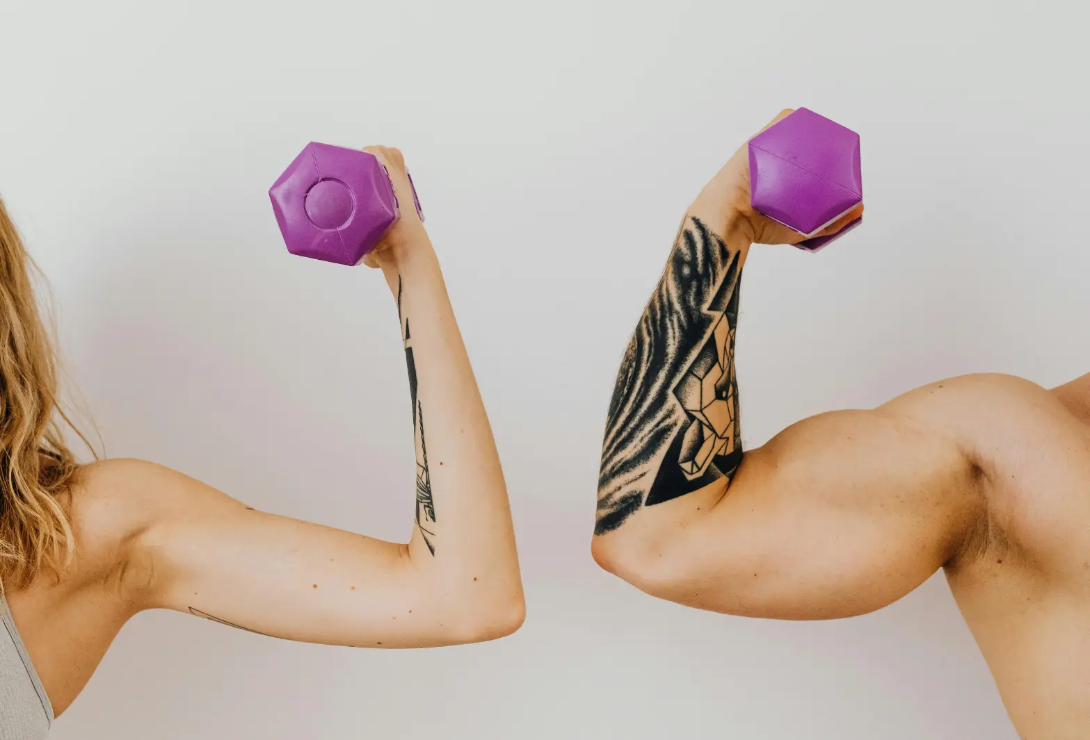 Deux personnes soulèvent des haltères violets, représentant la force et la nutrition sportive sans additifs de Protéalpes.