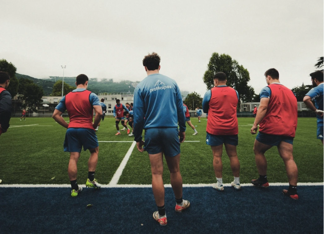 Rugby-Gruppe beim Training auf dem Spielfeld mit den Farben von Protealpes, dem Symbol für Sporternährung ohne Süßstoffe.