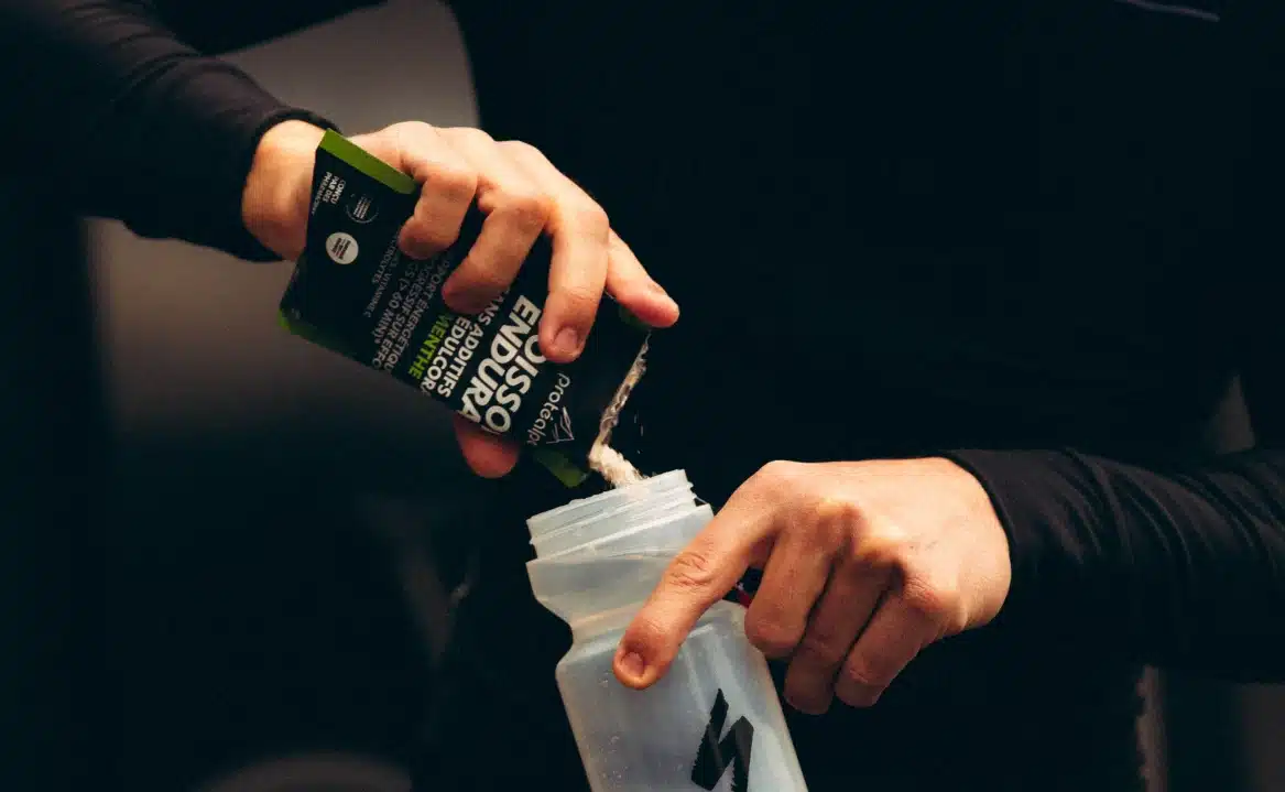 Athlete preparing a shaker with a Protéalpes product. Sports nutrition without sweeteners or additives.