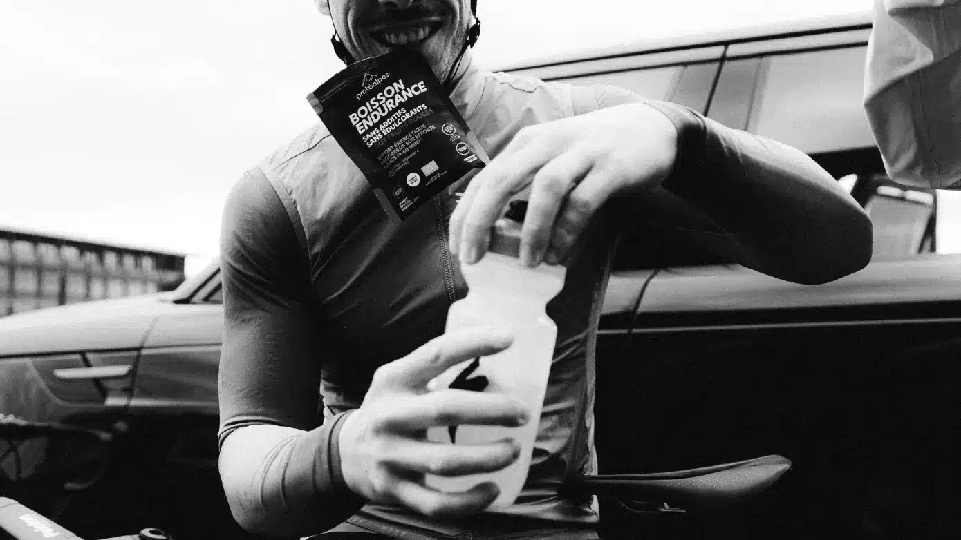 Un athlète prépare sa boisson Protéalpes, sans édulcorants ni additifs, pour une nutrition sportive de haute qualité.